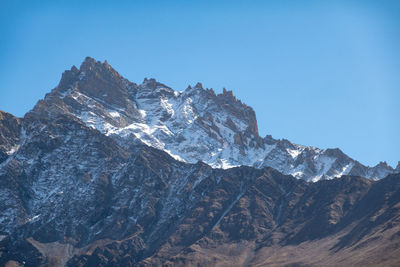 Scenic view of snowcapped mountains against clear blue sky