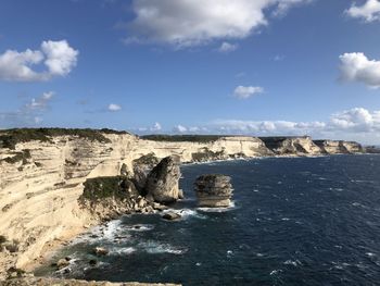 Rock formations by sea against sky