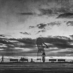 Silhouette of people against cloudy sky