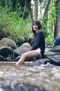 Young woman sitting on rock