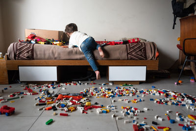 Rear view of man playing on sofa at home