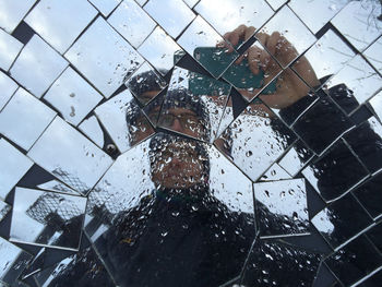 Reflection of man in wet mirror