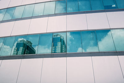 Low angle view of modern glass building in city