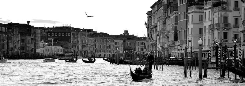 Panoramic view of boats in city against sky