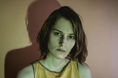 Dark portrait of serious young woman. green light