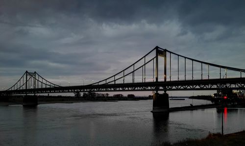 View of suspension bridge against cloudy sky