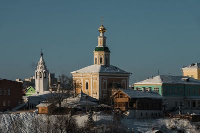 Buildings in city against clear sky