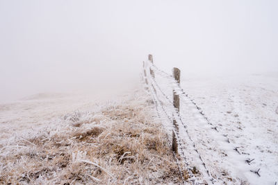 Scenic view of snow covered field against sky