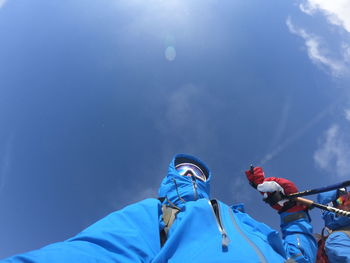 Low angle view of man against blue sky