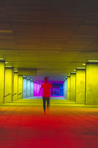 Rear view of man walking in tunnel