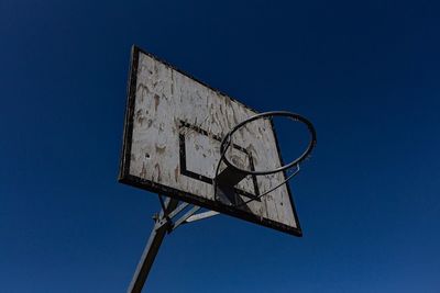 Low angle view of basketball hoop against clear blue sky