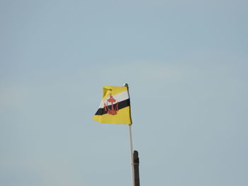 Low angle view of flag against clear sky