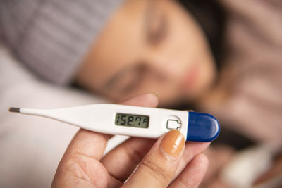 Cropped hand of woman holding thermometer