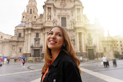 Tourist girl visiting murcia with the cathedral church of saint mary on the background murcia, spain