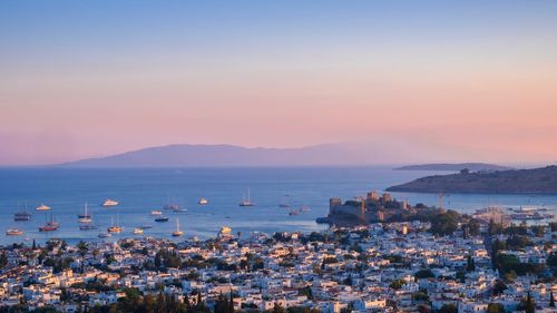 High angle view of townscape and sea at sunset