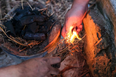 Close-up of hand burning firewood