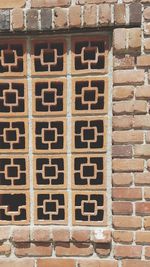 Close-up of metal grate against brick wall