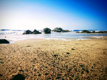 Surface level of beach against clear sky