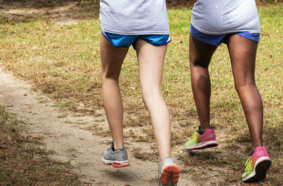 Low section of women walking on footpath