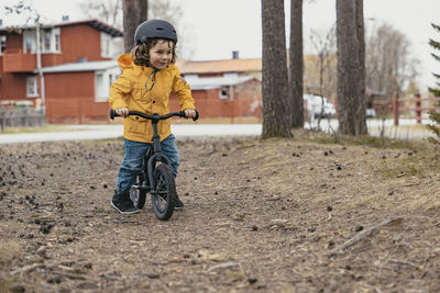 Boy on bicycle on dirt road in forest