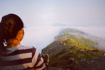 Rear view of woman looking at mountains against clear sky