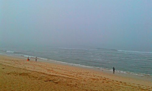 View of calm beach against clear sky