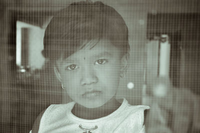 Portrait of boy looking through window