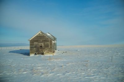 Abandoned house on snow covered landscape