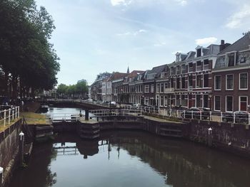 Canal amidst buildings against sky