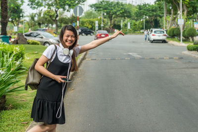 Portrait of young woman standing on road