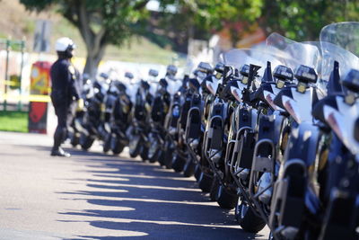 Man standing by motorcycles parked on road