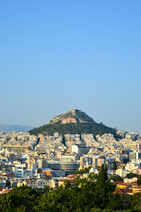 Buildings in city against clear blue sky