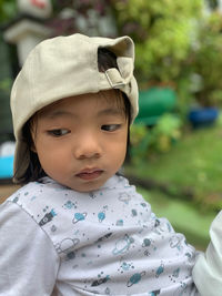 Boy wearing cap while looking away outdoors