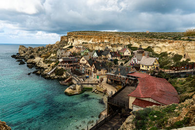 High angle view of houses and sea against sky