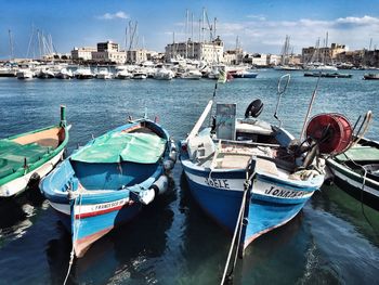 Boats moored at river against city