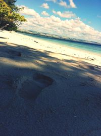 Scenic view of beach against cloudy sky