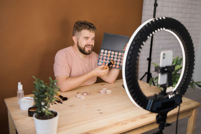 Portrait of young man using mobile phone on table