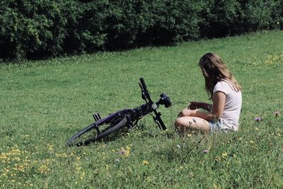 Woman on grass in field with bike