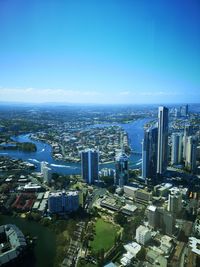 High angle view of modern buildings in city against blue sky