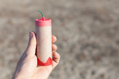 Cropped hand holding cracker outdoors