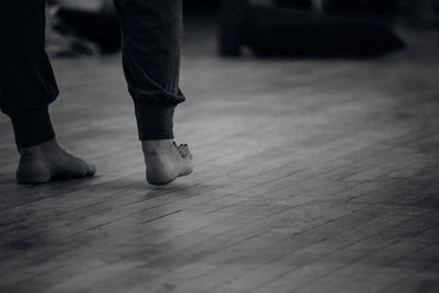 Low section of men standing on tiled floor