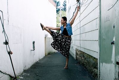 Woman dancing on street amidst buildings