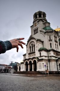 Cropped hand of woman against alexander nevsky cathedral