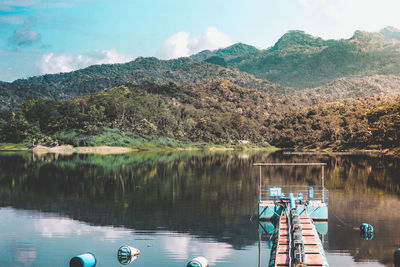 Scenic view of lake by mountains against sky