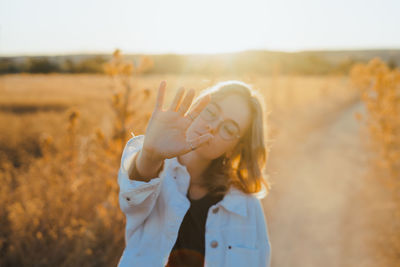 Midsection of woman standing on field against sky