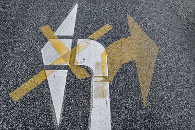 Close-up of yellow arrow symbols on road