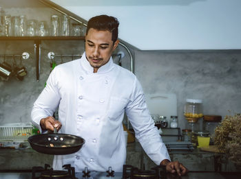 Young man preparing food in restaurant