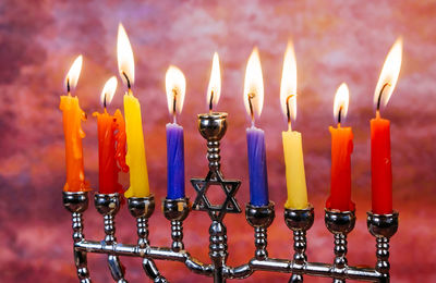 Close-up of lit candles on stick holder