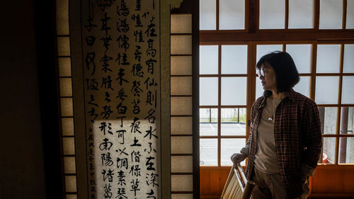 Woman standing against window