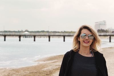 Portrait of smiling woman in sunglasses against sea